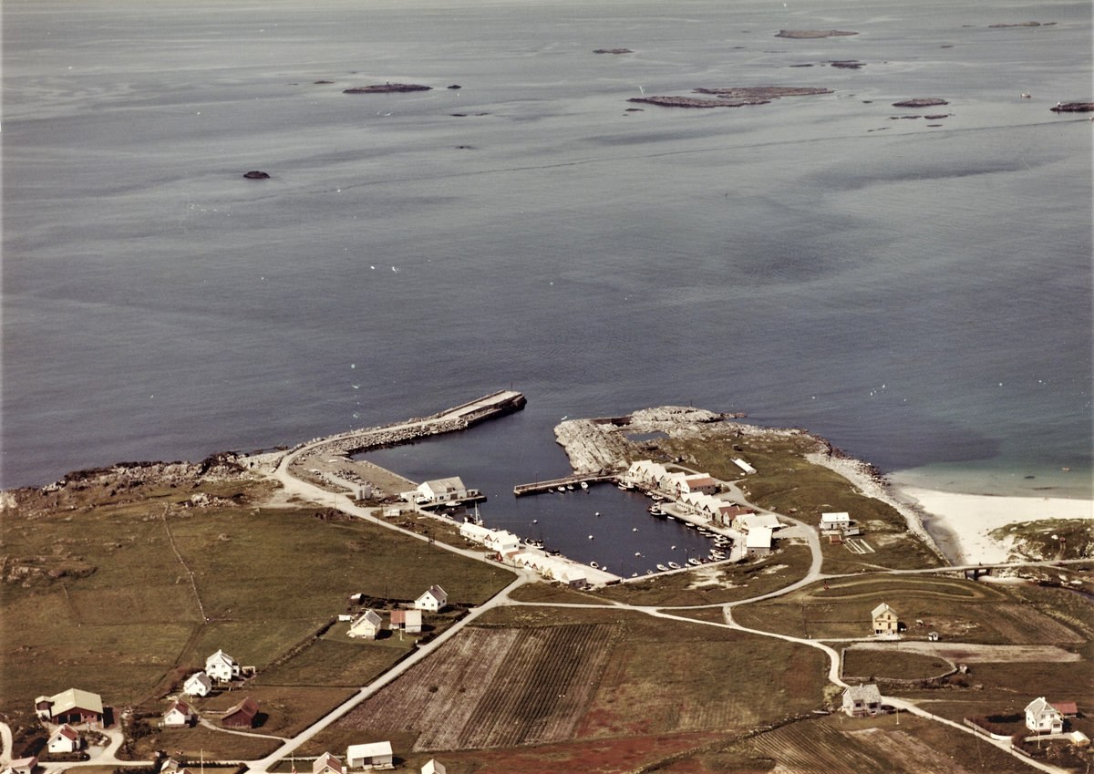 Flyfoto over Ferkingstad hamn på Karmøy. Det er tett med sjøhus og to mindre moloer inne i havna og en stor molo på utsiden. Til høyre er Stavasanden.