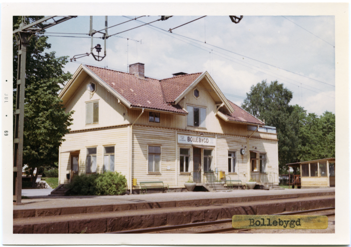Vy vid Bollebygd. Station anlagd 1893.Stationen avbemannad från 1 juni 1975. Stationshuset disponeras nu av ett svets- och smidesföretag. Stationen lastplats från 1983-12-08. Numera finns endast en öppen väntkur för de resande