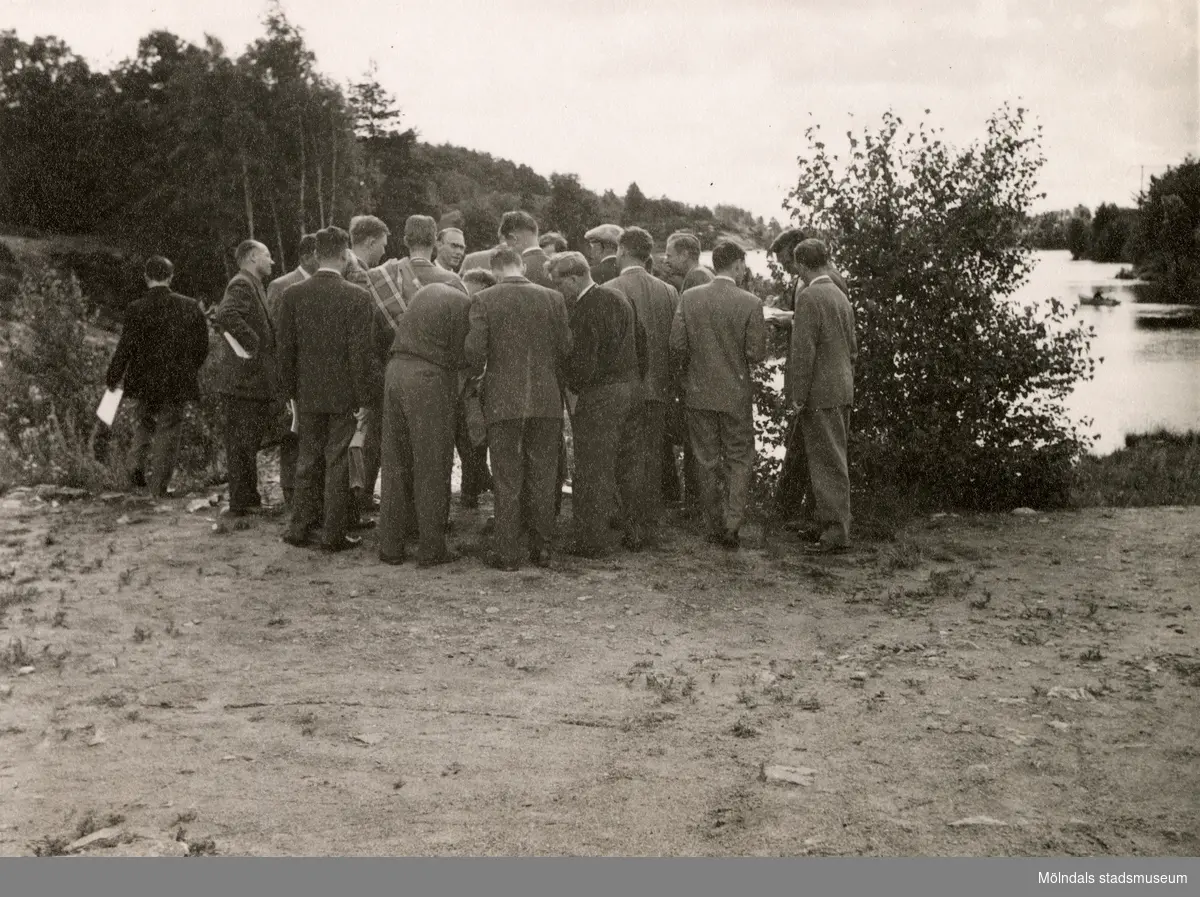 Ett antal män står samlade vid sjön Södra Långvattnet i Mölndal, okänt årtal.