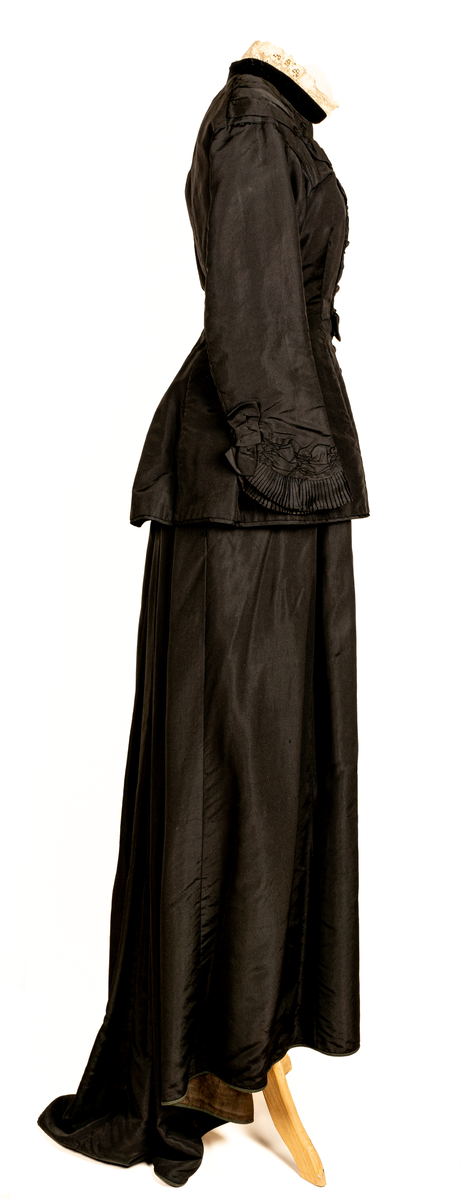Brudklänning, svart siden, sammet och spets i halsen. Kjol med släp.