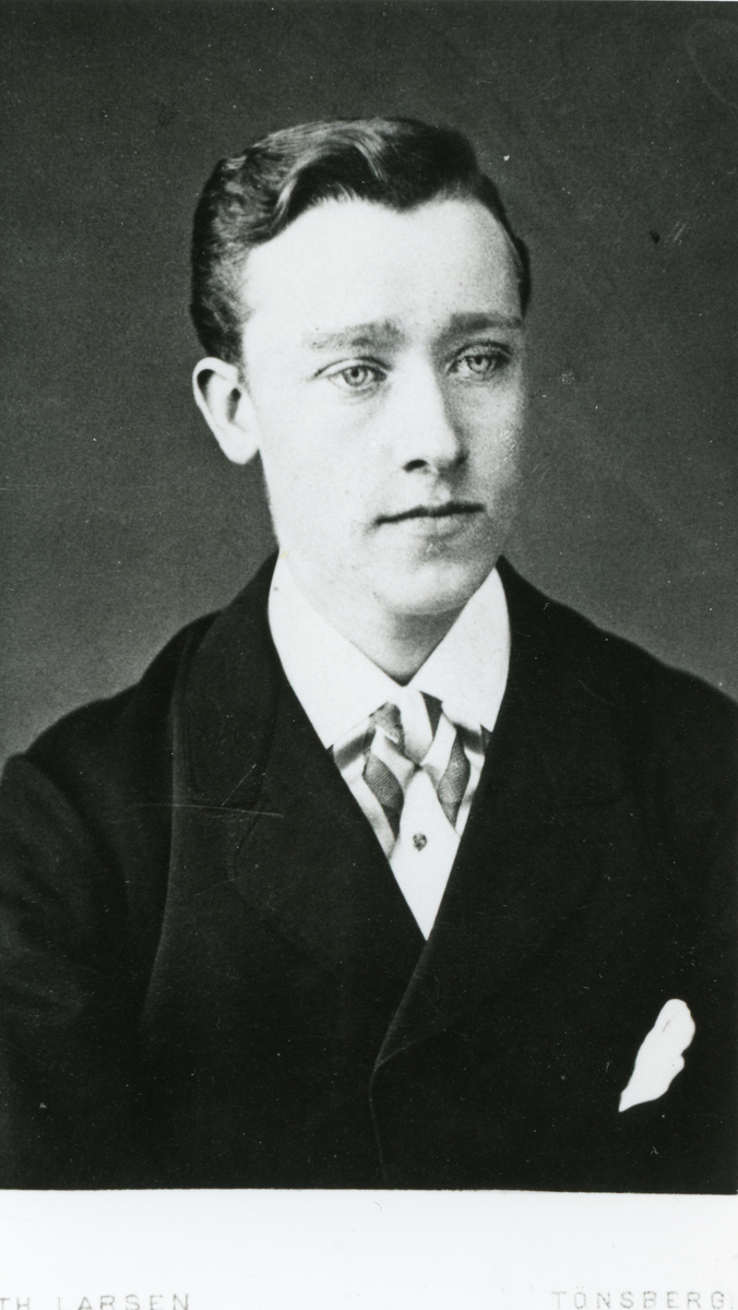 Portrett av mann med jakke,slips og skjorte.