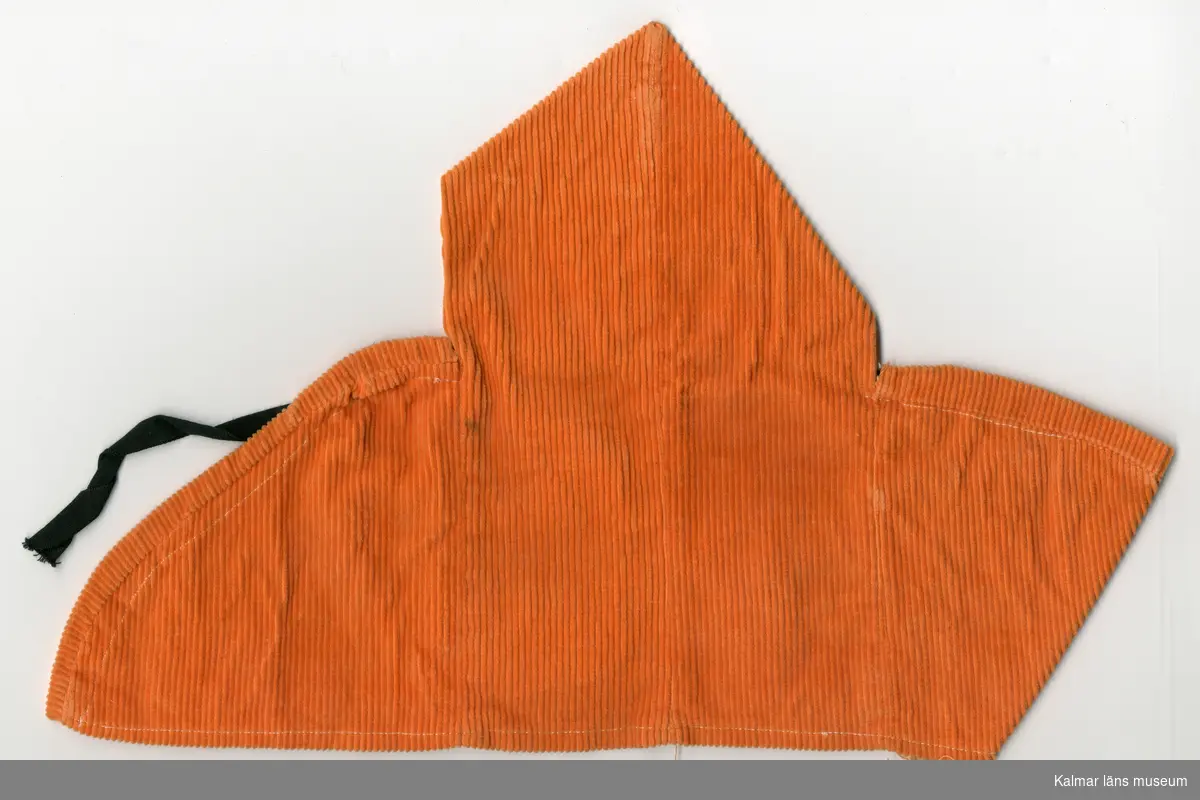 KLM 45519:16:7 Dockcape, av tunnspårig manchester, orange. Sydd i tre delar, dragsko sydd längs capens kant, där bomullsband, svart, dras och knyts, framtill vid hals.