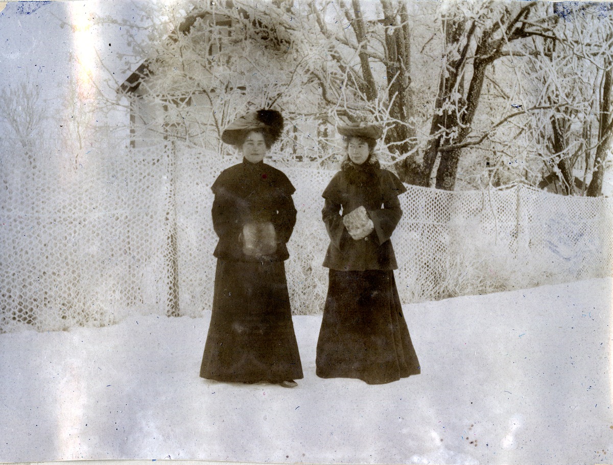 Aagot Henriksen og Sigrid Svendsen står ute, vinter 1903.
Bilde er fra fotoalbum GM.036887.