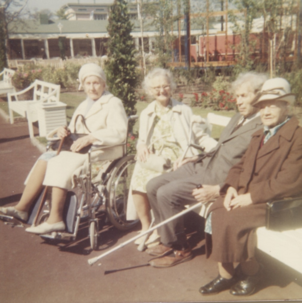 Brattåshemmets boende är på utflykt till Liseberg, 1970-tal. Från vänster: 1. Okänd kvinna i rullstol. 2. Okänd kvinna. 3. "trädgårdsmästare" Oskar Larsson (1893 - 1979). 4. Okänd kvinna.