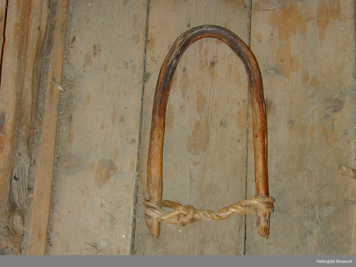 Et trestykke bøyd i hestesko. I den ene enden er en naturlig fortykning, i den andre enden et hakk, mellom endene en vidje.