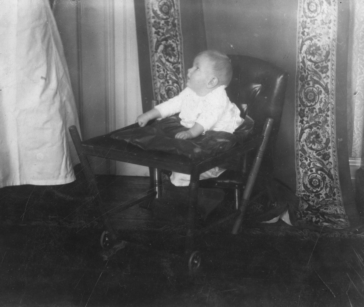 Spedbarn sitter i stol i 1912. Antagelig Niels Frederik Aall som baby
