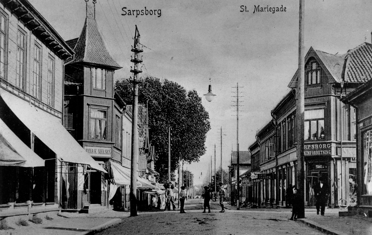 St. Marie gate i Sarpsborg, ca. 1905. Postkort. Til venstre forretningen til Anna K. Nielsen, til høyre Sarpsborg Maskinforretning.