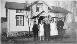Leirfjord, Leland. En gruppe personer fotografert foran huse