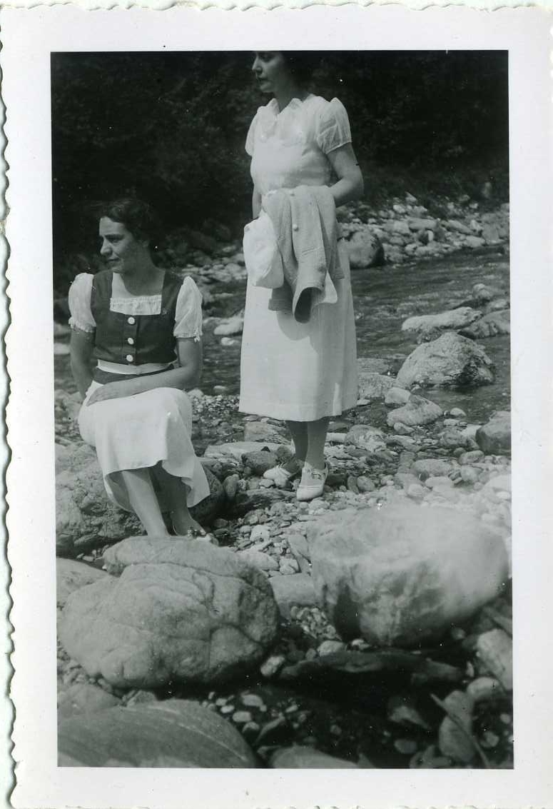 Två sommarklädda kvinnor vid ett vattendrag, en sitter på huk. Kvinnan till höger är Marcelle Machuron.