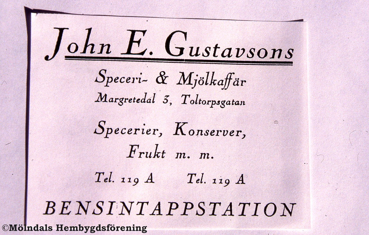Toltorpsdalen i Mölndal, okänt årtal. John E. Gustavson annonserar för sin affär, Toltorpsgatan 65.