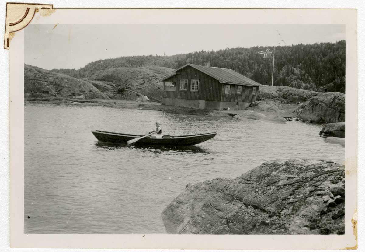 Foto av forfatter Tor Åge Bringsværd som ror pram i nærheten av leid hytte i Åbyfjorden