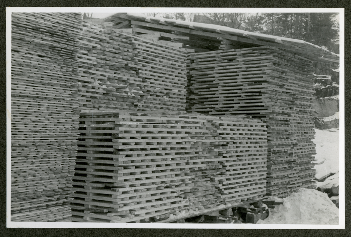 Foto av paller med tremateriale ved Aall-Ulefoss Brugs Dørfabrikk