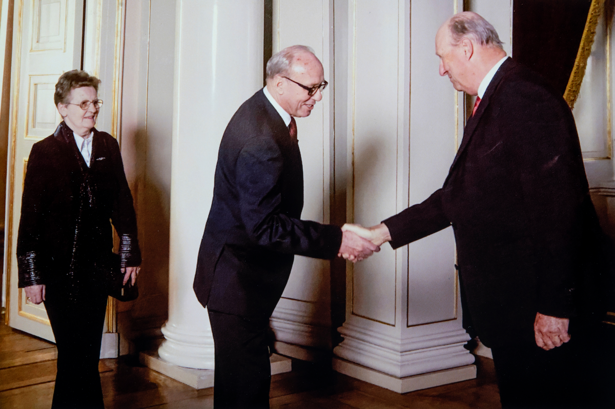 Odd Aspeli er på Slottet for å takke HM kong Harald for fortjenestemedaljen i gull som Odd ble tildelt i 2008. Gerd Aspeli står bak sin mann.