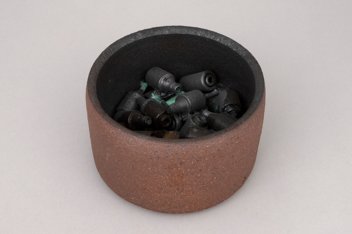 To sylindriske skåler i kobberoksidert steingods med funne sikringer.