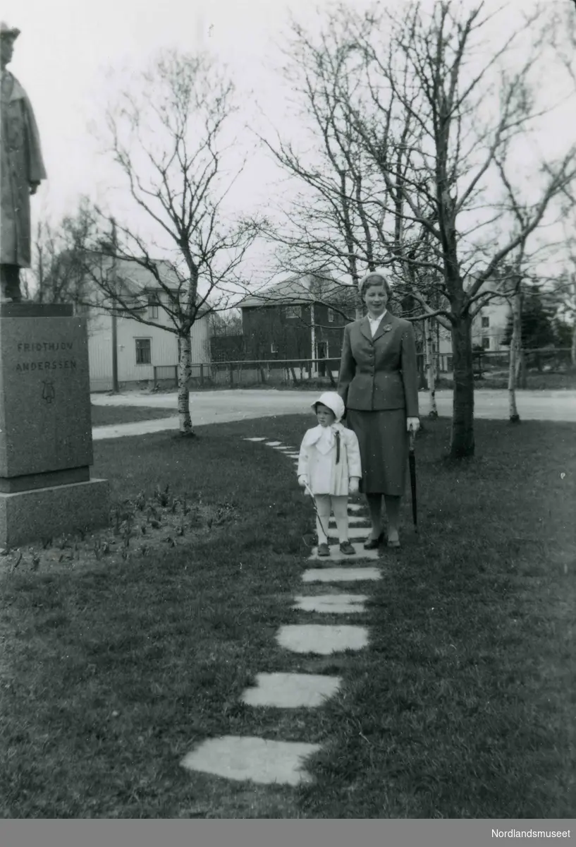 En kvinne og en liten jente ved statuen av Fridtjof Andersen, Bodø. Bildetekst: "Dame og Kristin i Solparken. Sikkert 17. mai".