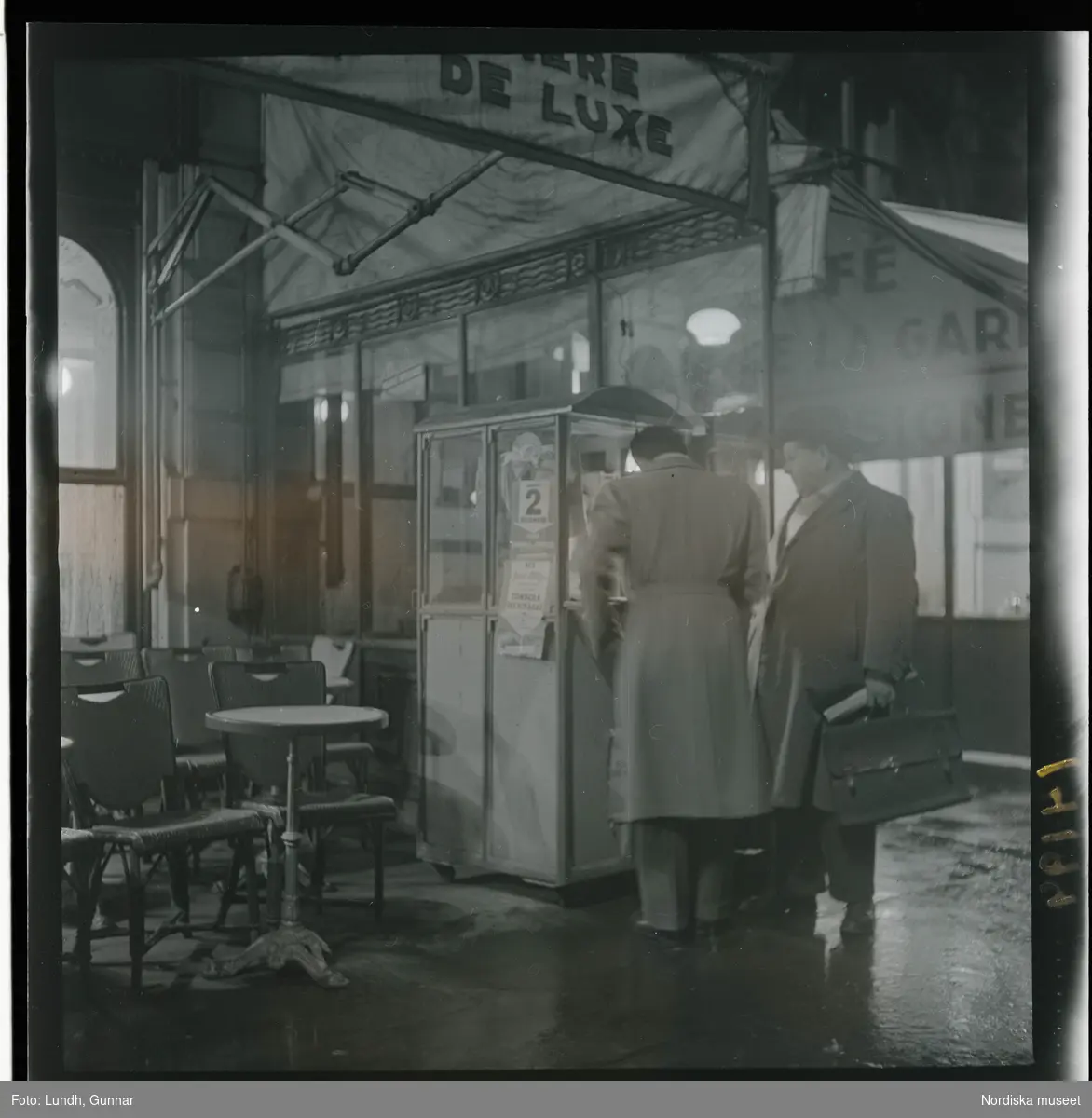 1950. Paris. Två män utanför ett café, kväll