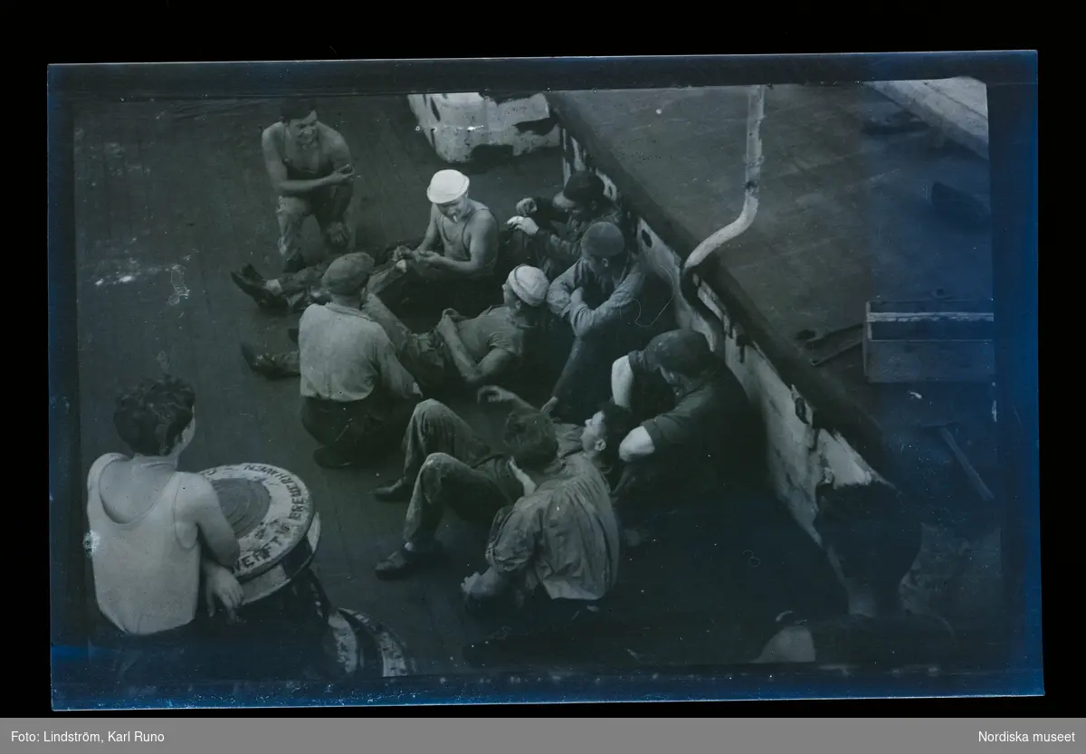 Besättningsmän sitter och vilar på däck.