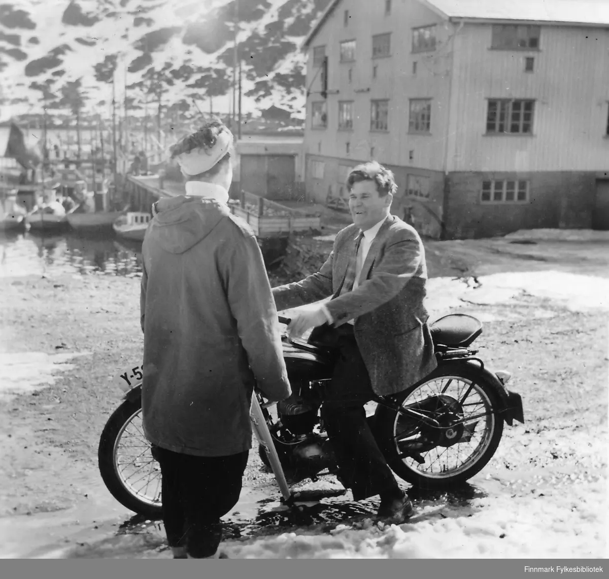 Havøysund 1957.  En dame prater med Trygve Olsen som sitter på motorsykkel.