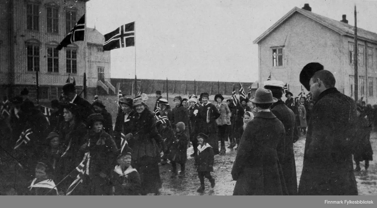 17.mai i Vadsø, 1918. Barnetoget går forbi skolen. I forgrunnen Arvid og Sigrid Dahl.