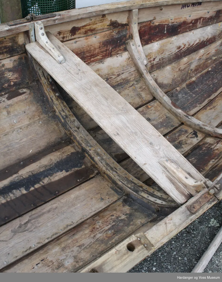 Klinkbygget pram av furu. Den er lagd i to deler og skrudd sammen på midten. Båten har en fastsittende tofte og et par tolleklamper.