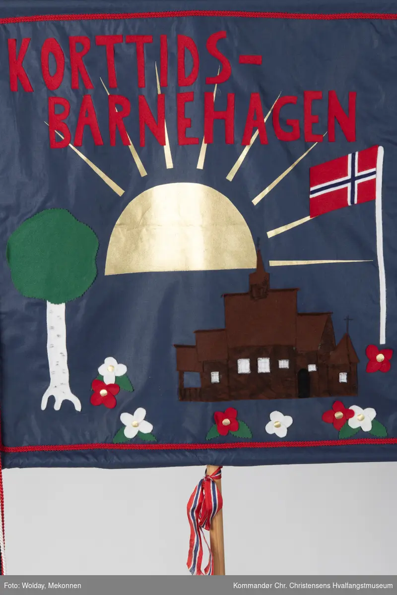 Mørkeblå bakgrunn. Rød skrift, dekorert med en sol, Høyjord stavkirke, norsk flagg, tre og blomster.