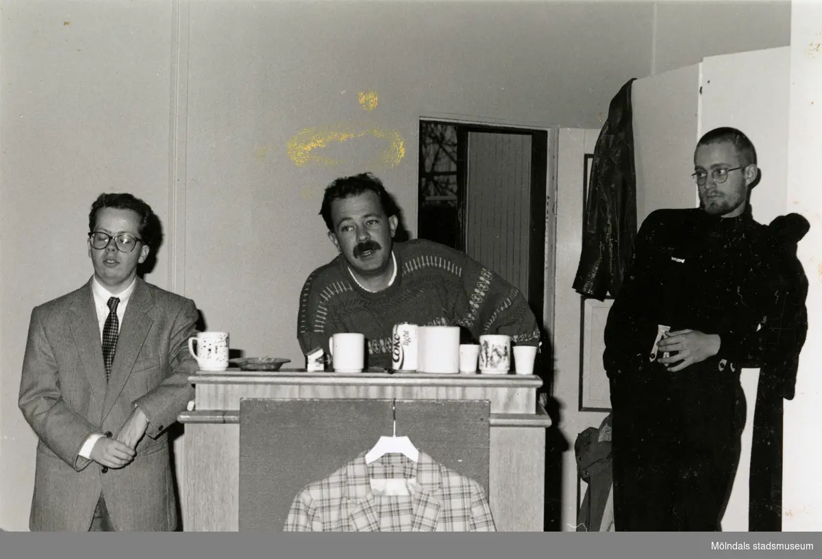 Tre män står bakom en talarstol i gamla Teaterhuset (före detta Missionskyrkan), okänt årtal. Från vänster: skådespelare Mikael Fjelldal, amatörteaterkonsulent Janne Sandberg samt en okänd man.