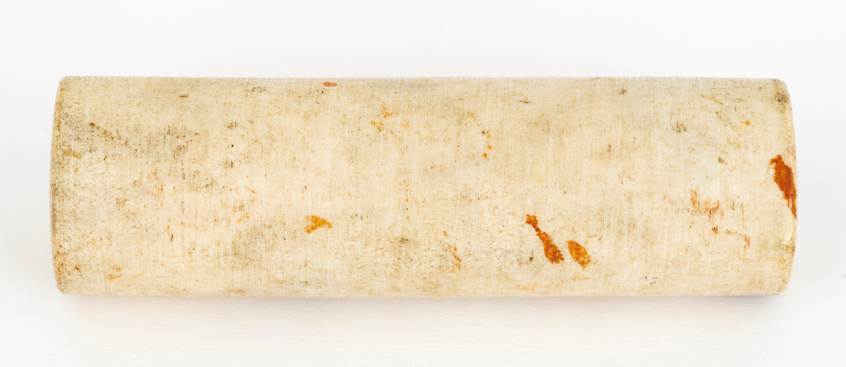Knivskaftemne, lagd av et beinmateriale som da gjenstanden ble innregistrert i Norsk Skogmuseums samlinger ble hevdet å være av elggevir. Emnet er sylindrisk, snaut 11,4 centimeter langt og med en diameter på 3,4 centimeter. Endeflatene har hull etter festene i spindelen og motspissen på dreiebeken, og på de sylindriske ytterveggene kan man ane spor etter et flatjern. Emnet har ei gråkvit overflate.