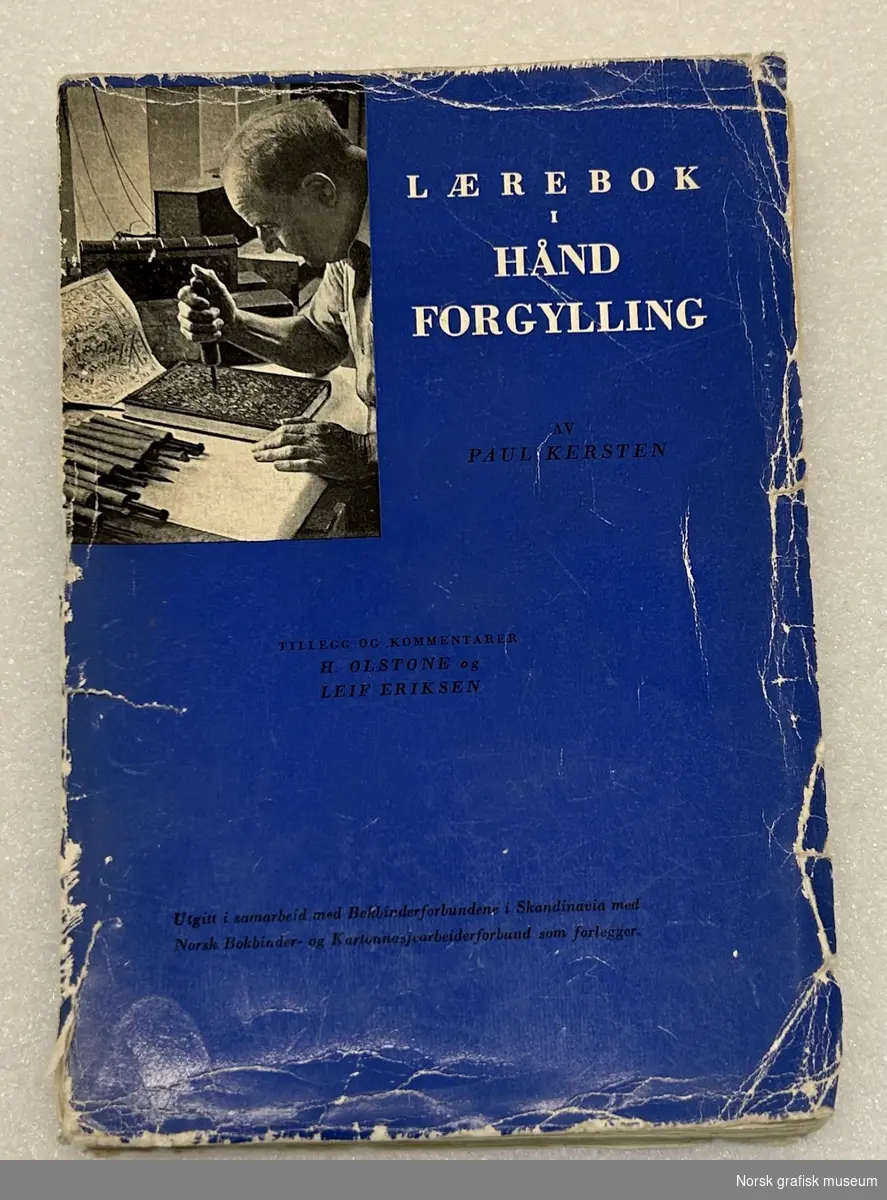 Lærebok i håndforgylling, utgitt 1947. Deler av ryggen har løsnet og omslaget er slitt.