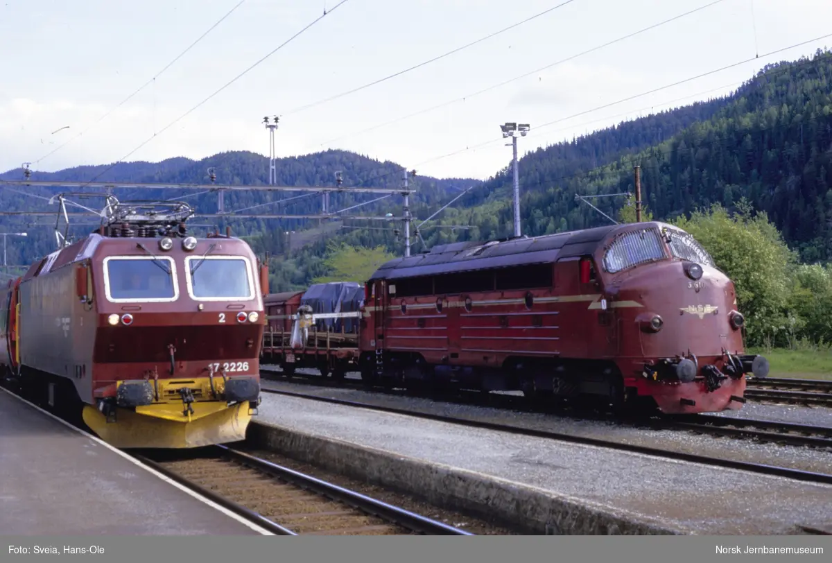 Elektrisk lokomotiv El 17 2226 med ekspresstog til Oslo S over Dovre (t.v.) og diesellokomotiv Di 3 610 med godstog til Hamar over Røros, på Støren stasjon
