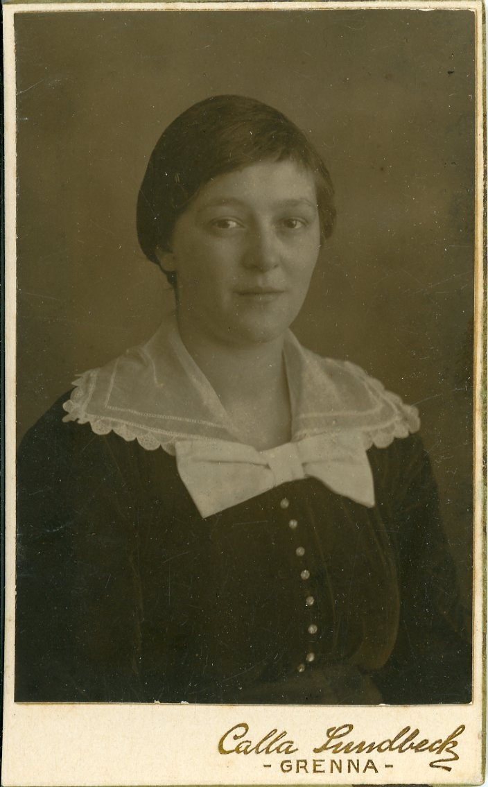 Porträtt av en ung kvinna i mörkt med vit spetskrage.