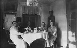 Gruppebilde. Familie samlet rundt kaffebordet i stua.