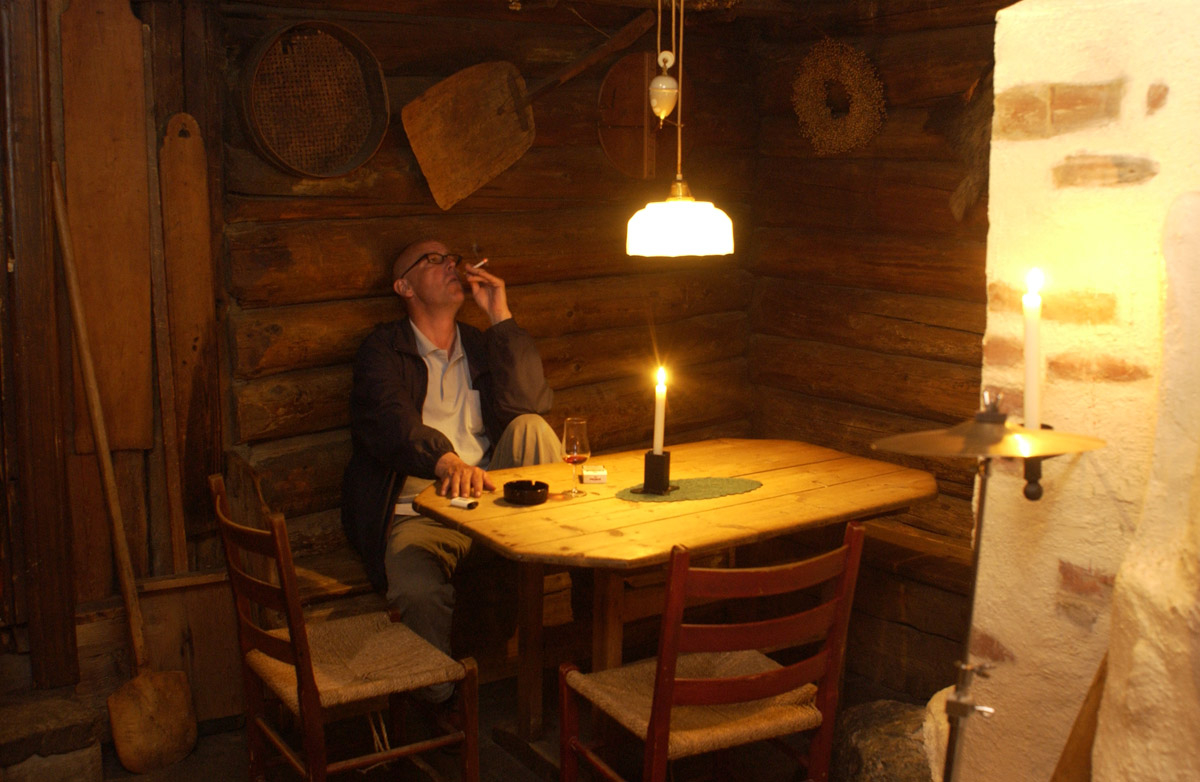 Siste 1/2 time før røykeloven trer i kraft. Mann ved bord. Med sigarett og et glass vin. Det Gamle Bageri Ost & Vinstue.