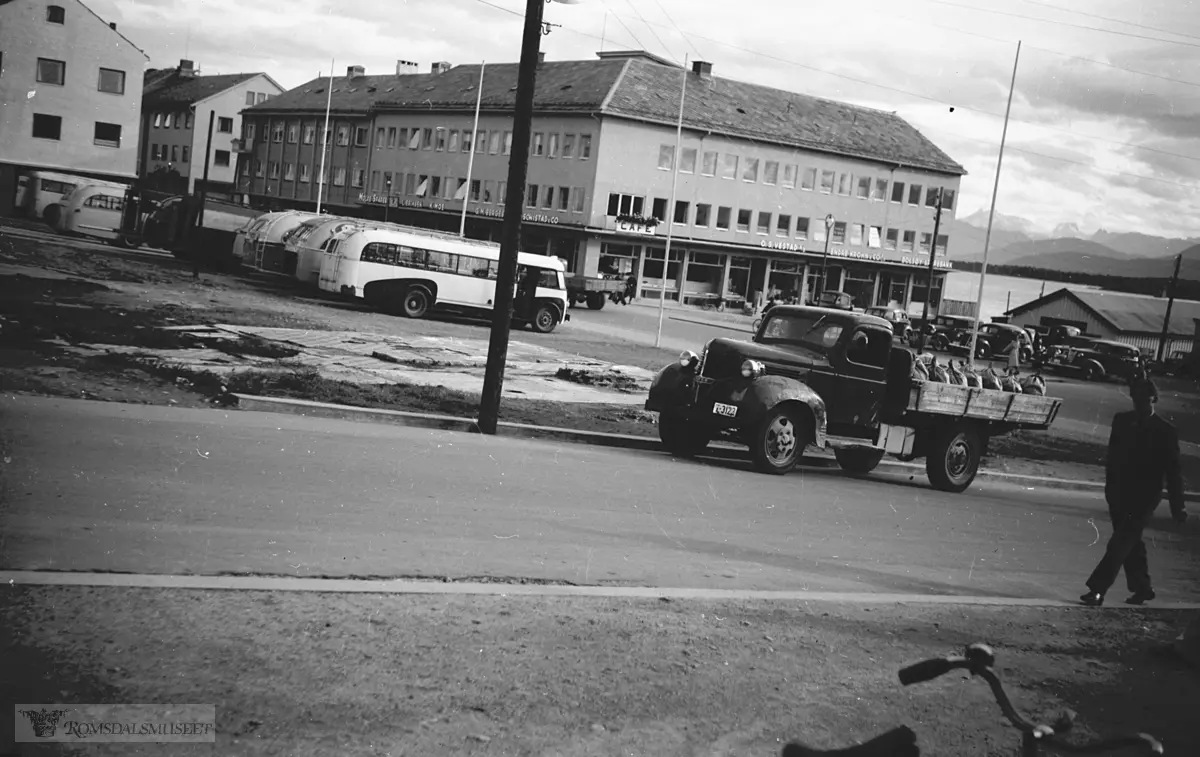 Molde, Torget med O.S.Vestad A/S. Molde Sparebank. L.Eriksen. K.Moe. G.M.Bergesen. Schistad & Co..Lastebil reg nr. T-3123..Lastebilen er en Dodge eller Fargo 1939.