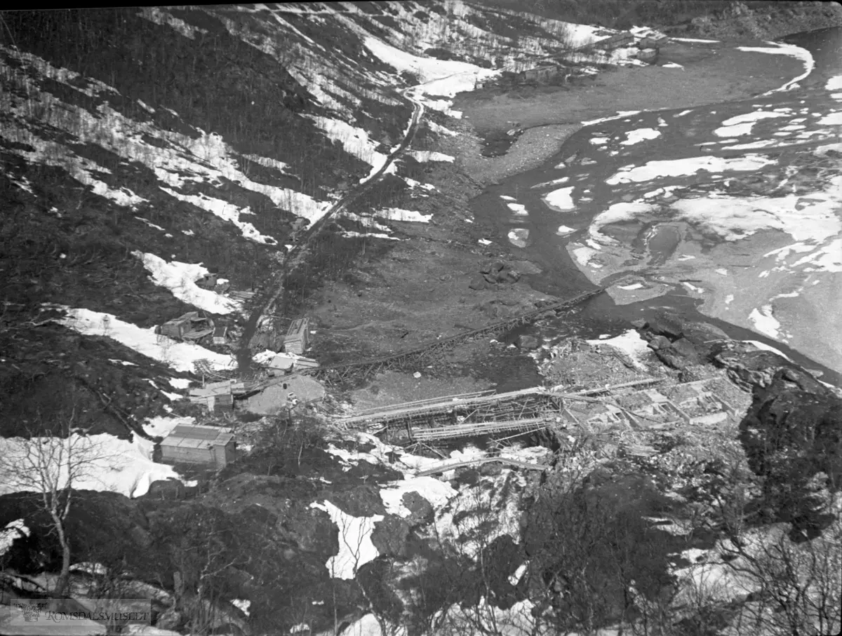 Frå bygginga av kraftstasjonen i Hallarvassfossen. .I bakgrunnen ser vi Nedre Sandvatnet med Arbeiderbrakkene i Sandvassøya lengst bak. Det var det tyske firmaet Nordag som kjøpte Aura-anlegget av Bergen Privatbank. De tyske planene ble skrinlagt i 1943.