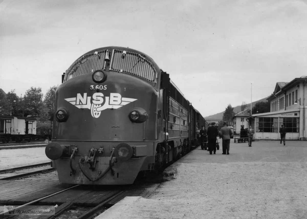 Nattoget Oslo-Åndalsnes morgenen 1.juni.1958, det første på Raumabanen med diesel-lokomotiv (3.605)...De to herrene med ryggen mot er lokomotivmester og stasjonsmester Tangen. Lokomotivet var grønt.