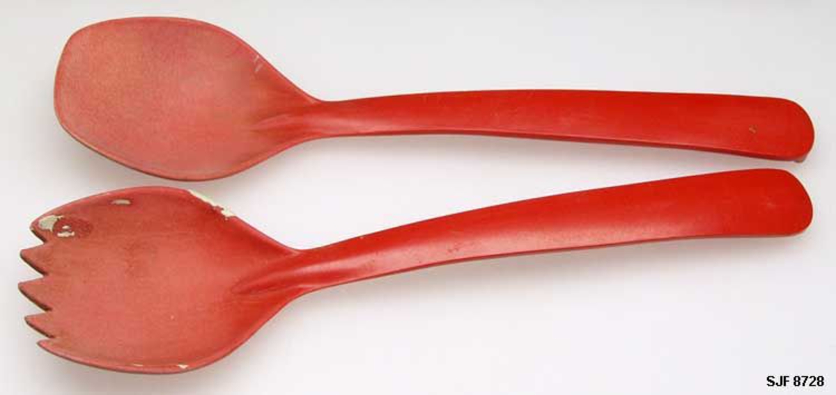 To sleiver, utført i rød plast. I tillegg til samme materiale og samme farge, har de to objektene også likhetstrekk med hensyn til dimensjoner og design, så det er sannsunlig at de har vært innkjøpt som deler av et sett. I forbindelse med aksesjonen fikk de betegnelsen salatbestikk. Akkurat den funksjonen kan det være grunner til å betvile, både på grunnlag av gjenstandenes form og fordi eierne - Anna (1885-1976) og Iver Eide (1886-1976) - tilhørte en generasjon og et sosialt miljø som neppe konsumerte særlig mye salat. Det er mer sannsynlig at disse sleivene har vært brukt til å røre i kokekar med sikte på å forebygge at mat som var under varmebehandling skulle «svi seg» fast i botnen på grytene.

SJF.08728-01
Ei forholdsvis lita kjøkkensleiv, støpt i rødfarget plast. Sleiva er 22,2 centimeter lang. Det skålformete skjebladet i den fremre enden er om lag 7,5 centimeter langt og 5,7 centimeter bredt. Skåla her rommer cirka 35 milliliter væske. Skaftet er rett, i forlengelsen va skjebladets midtakse. Bredden tiltar noe mot den ytre enden, som er avrundet. På undersida der er det en liten, nedovervendt tapp, som antakelig skulle forebygge at sleiva skled fra kanten på ei gryte eller en bolle og ned i beholderen. Undersida av skaftet har innstøpt en bokstav- og tallkonstellasjon: «NORSK 7450 A».


SJF.08728-02
Ei forholdsvis lita kjøkkensleiv, støpt i rødfarget plast. Sleiva er 22,1 centimeter lang. Det skålformete skjebladet i den fremre enden er om lag 7,3 centimeter langt og 5,6 centimeter bredt. Her har den fremre enden en takket ytterkant. Skaftet er rett, i forlengelsen va skjebladets midtakse. Bredden tiltar noe mot den ytre enden, som er avrundet. På undersida der er det en liten, nedovervendt tapp, som antakelig skulle forebygge at sleiva skled fra kanten på ei gryte eller en bolle og ned i beholderen. Undersida av skaftet har innstøpt en bokstav- og tallkonstellasjon: «NORSK 7450 B». På sleivbladet er det noen flekker av et gråkvitt stoff, muligens maling.