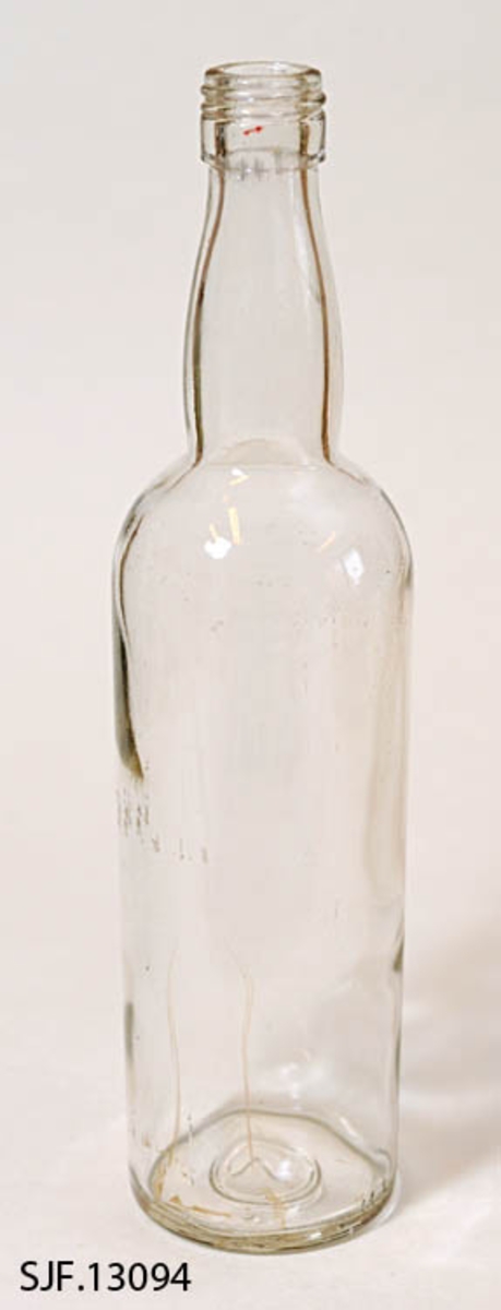 Flasken er av klart glass, og har en sylindrisk form. Den har flat bunn. 