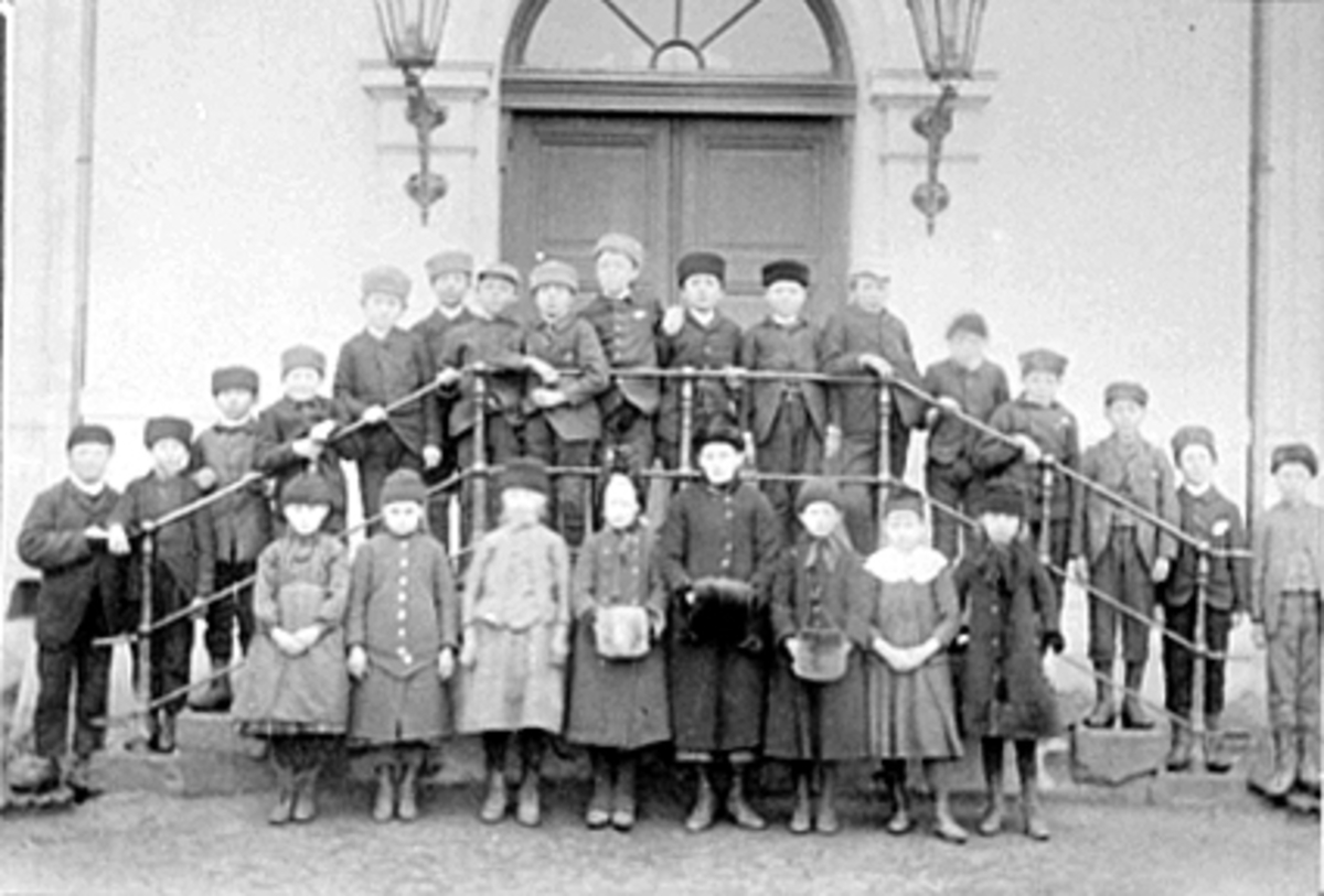 Stor gruppe skoleelever ved Midtbyen skole i Hamar. 
Nr. 8 fra venstre 2 rad: Hans Walberg F. 1879, nr. 6 fra venstre 1 rad: Petra Walberg gift Kristiansen. De var tvillinger, skoleklasse, lærer Nella Trøfting, folkeskolen. 
