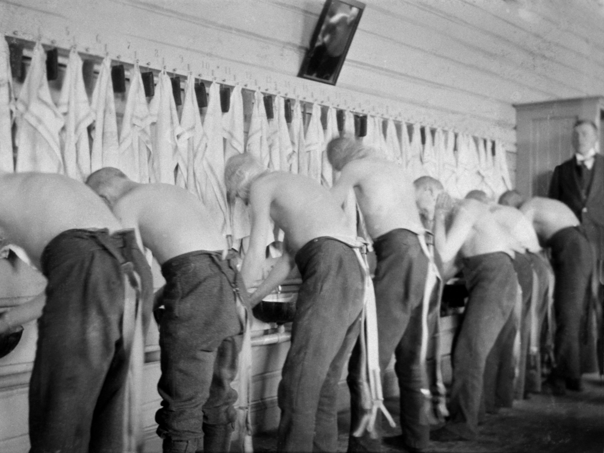 Interiør fra vaskerom. Gutter som vasker seg mens lærer passer på. Toftes Gave, Nedre Sund, Helgøya.