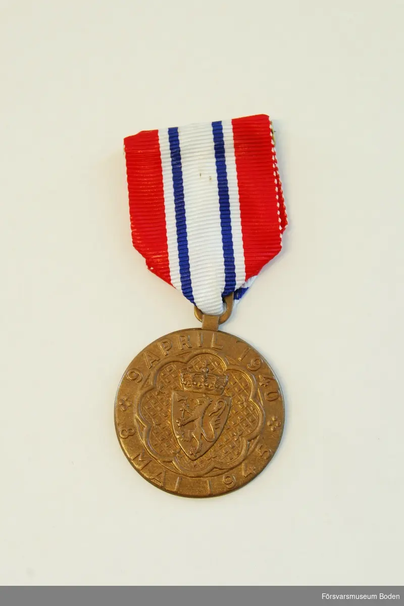 Medalj i brons med tillhörande släpspänne och urkund.