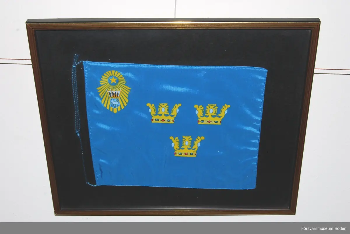 Inramad bordsfana, ljusblå med tre gula öppna kronor i mitten. Övre vänstra hörnet försett med gul stjärna omgiven av strålknippe, vars nedre del innehåller landskapet Västerbottens vapen krönt med hertigkrona. Den ursprungliga fanan överlämnades 1935 av konung Gustaf V.