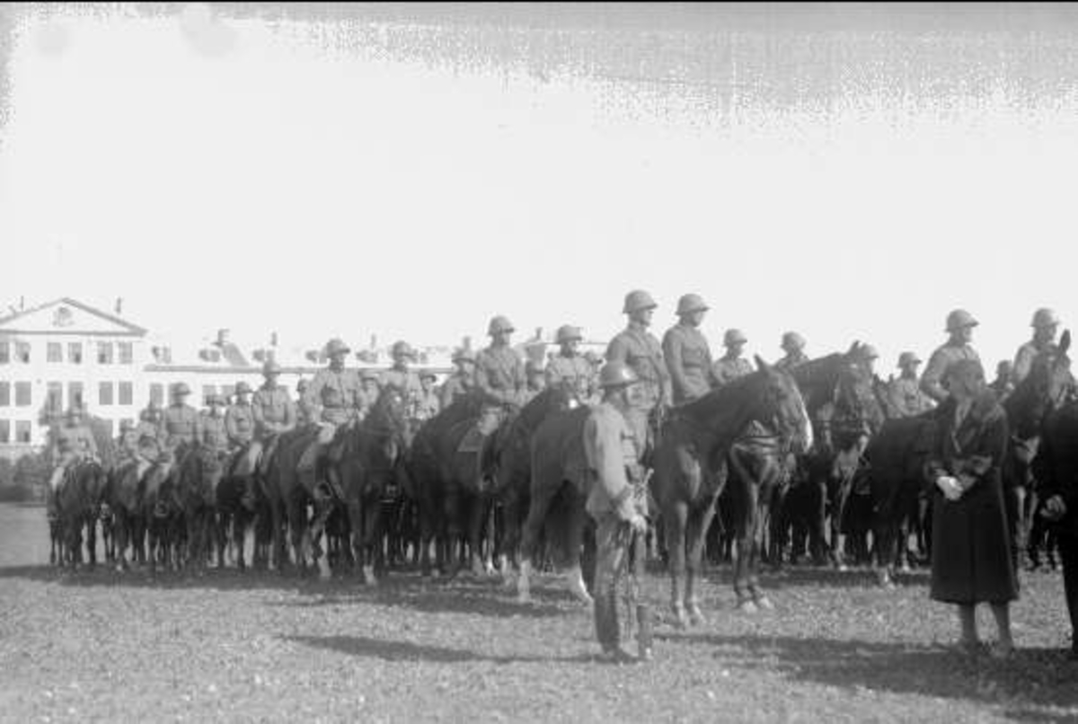 Kamratföreningens medlemmar med fruar på besök vid regementet 1931. Regementet uppställt för korum på fältet söder kasern.