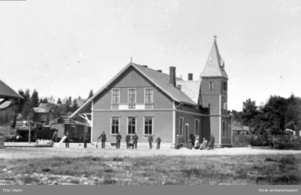 Ski stasjon; personalet og stasjonsmesterens familie foran bygningen, damplokomotiv type 9 med persontog i spor 1