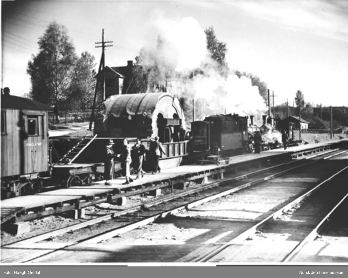 To damplokomotiver, type 27a og 18a, foran Rjukanbanens dyplastevogn, lastet med en 60 tonns stålsylinder til Mesna Tresliperi & Kartonfabrik