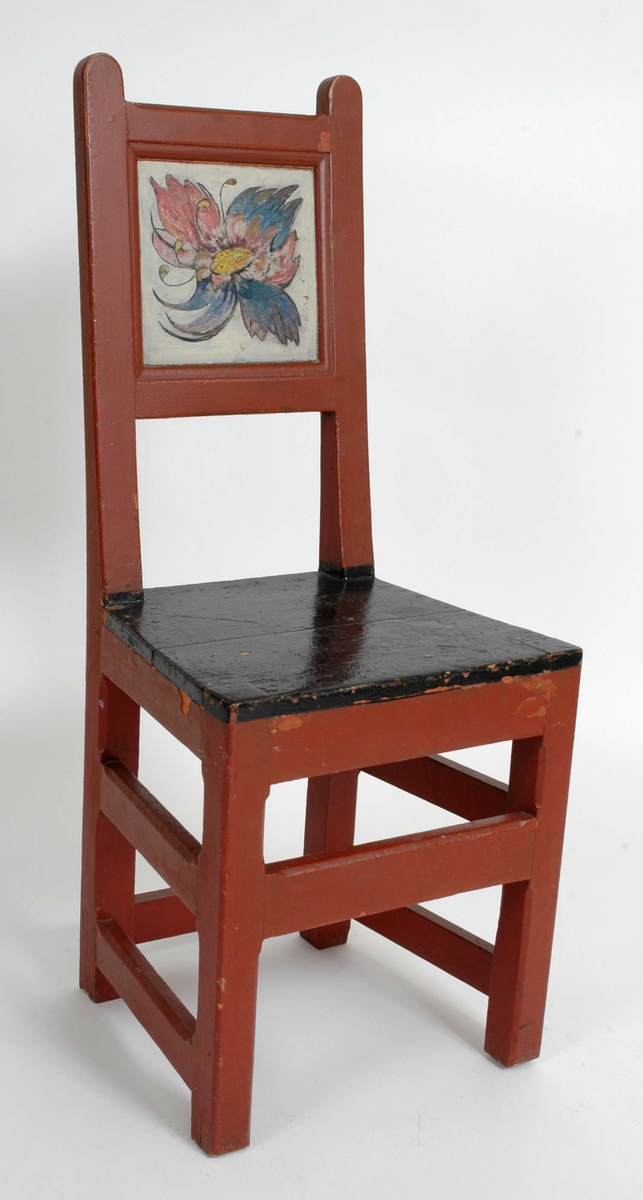 Rødmalt stol med svart sete og dekormalt ryggplate.