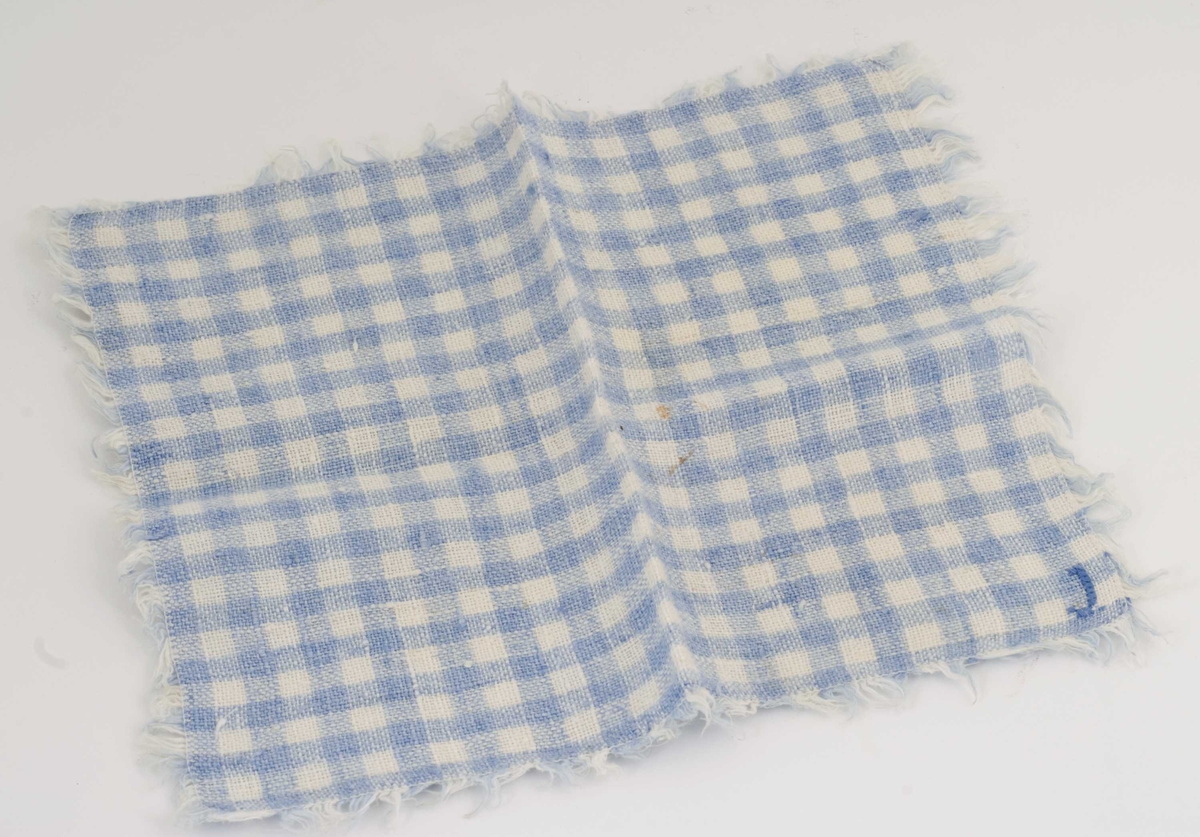 Fem blå og hvite, smårutete servietter med frynser 