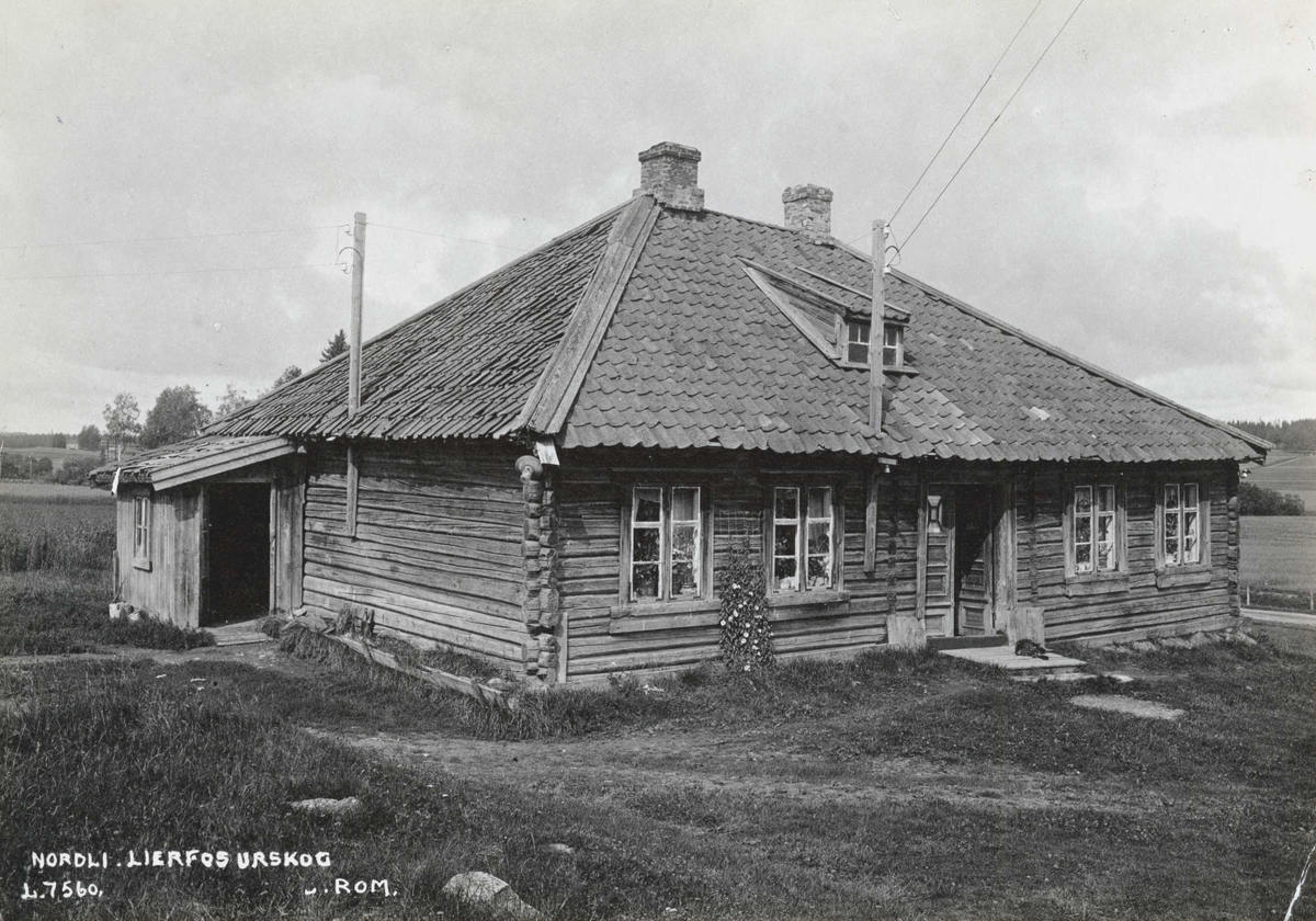Nordli, Aurskog-Høland, Nedre Romerike, Akershus. Lavt tømmerhus sett mot gårdsplassen.