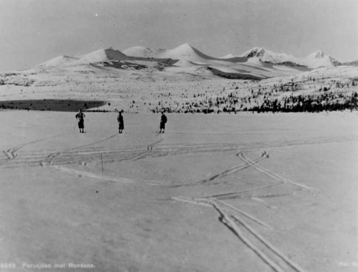 Avfotografert postkort. Tre skiløpere på Furusjøen i Rondane.