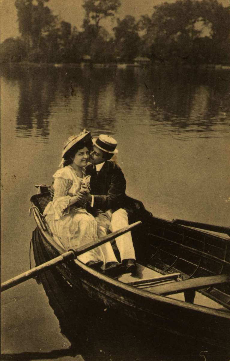 Postkort. Jule- og nyttårshilsen. Fotografisk motiv. Sommermotiv. Flørtende par i robåt. Stemplet 22.12.1903.