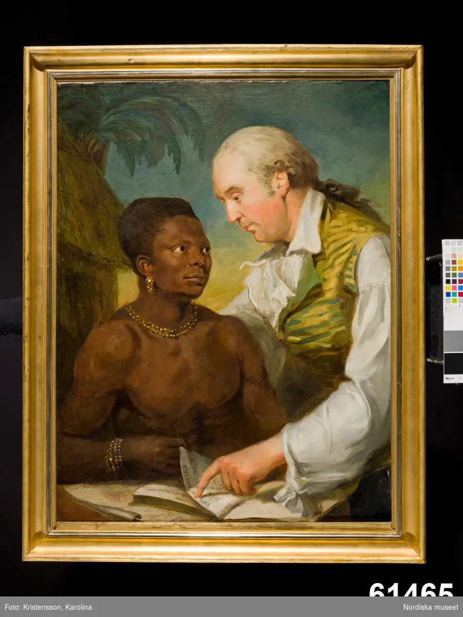 Dubbelporträtt med två män. påklädd man med västeuropeiskt utseende lutar sig över och undervisar, avklädd man med afrikanskt utseende. Dubbelporträtt med friköpt slav.